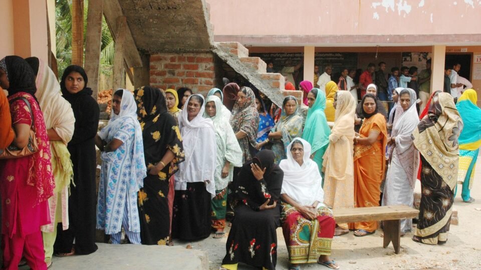 मतदान केंद्र पर कतार में खड़ी महिला मतदाता